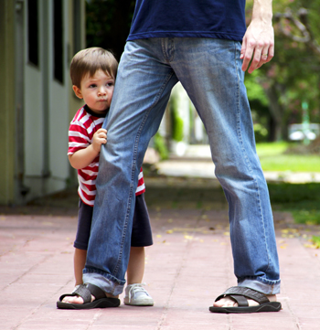 Baby making their first steps with the help of his father